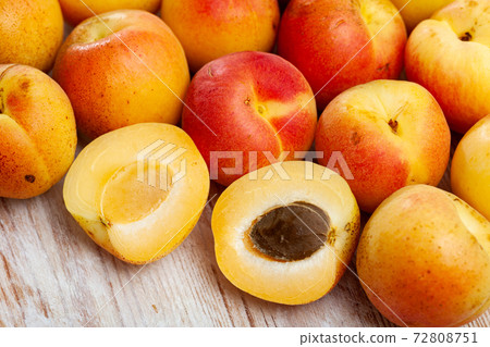 Fresh apricots whole and halves on wooden table 72808751