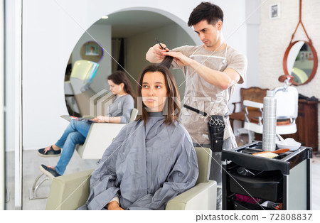 Stylist doing haircut for woman in salon Stylist doing haircut for woman in salon 72808837