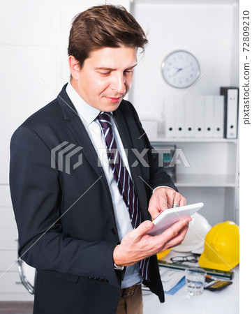 Man working and touching screen in the office Man working and touching screen in the office 72809210