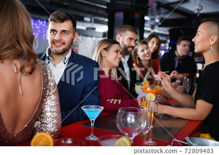 Young cheerful people with cocktails having fun at nightclub Young cheerful people with cocktails having fun at nightclub 72809483
