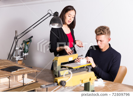Female student with friend creating architectural model Female student with friend creating architectural model 72809796