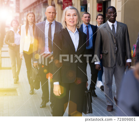 People walking down street in downtown People walking down street in downtown 72809801