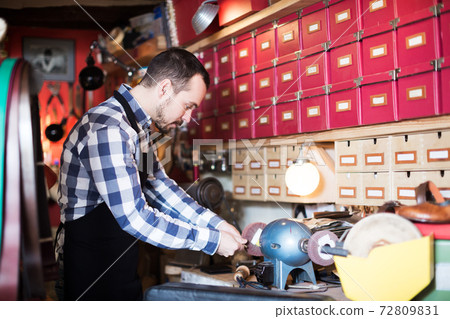 Worker preparing buckle for belt 72809831