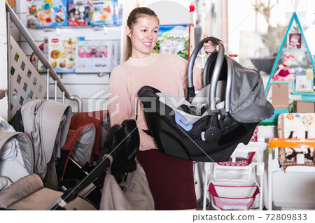 woman with infant's car cradle woman with infant's car cradle 72809833