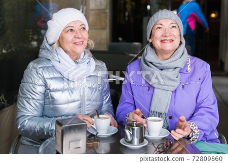 Smiling elderly females at outdoor cafe Smiling elderly females at outdoor cafe 72809860