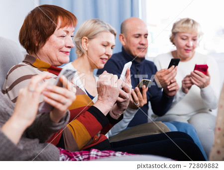 Mature women and man are resting with smartphones Mature women and man are resting with smartphones 72809882