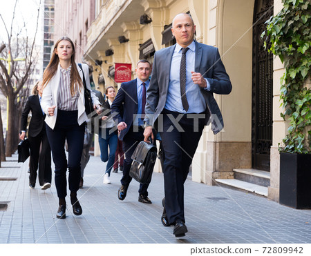 Hurrying people with stressed man in foreground 72809942