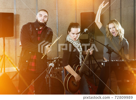 group of rock musicians posing with instruments group of rock musicians posing with instruments 72809989