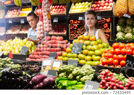 Female seller offering vegetables on market 72810495