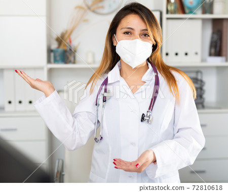 Female doctor in mask welcoming to clinic Female doctor in mask welcoming to clinic 72810618