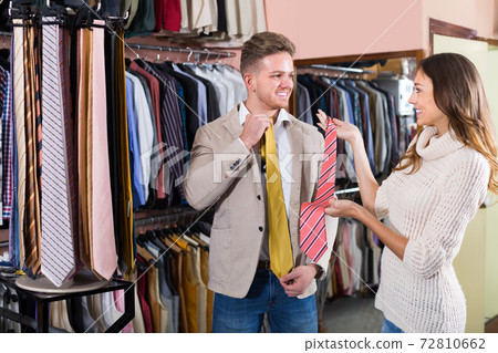 joyous young couple examining various ties 72810662
