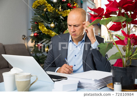 Concerned man working with laptop Concerned man working with laptop 72810984