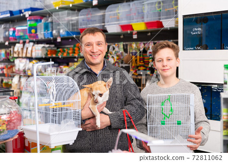 Happy man with teenager son and little dog buying pet supplies Happy man with teenager son and little dog buying pet supplies 72811062