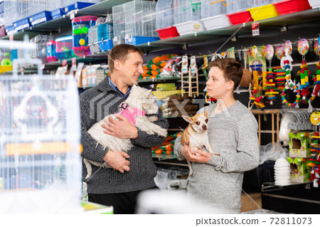 Father with son and little dogs choose products for animals in petshop Father with son and little dogs choose products for animals in petshop 72811073