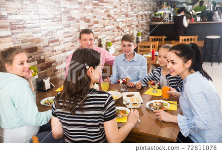 Group of adults and teenagers spending time in cafe Group of adults and teenagers spending time in cafe 72811078