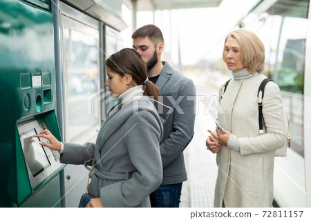 Brunette buying ticket in street vending machine 72811157