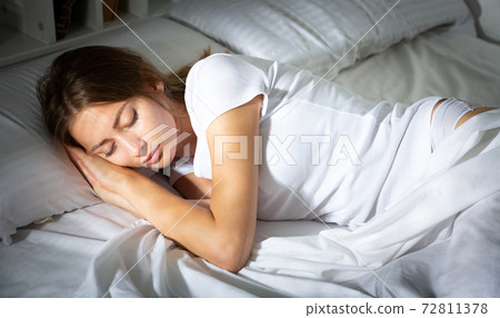 Pretty girl sleeping deeply in bed in morning Pretty girl sleeping deeply in bed in morning 72811378