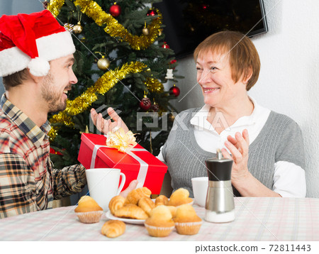 Mother and son exchanging Christmas gifts Mother and son exchanging Christmas gifts 72811443