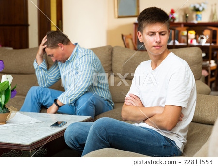 Man scolding his offended young son 72811553