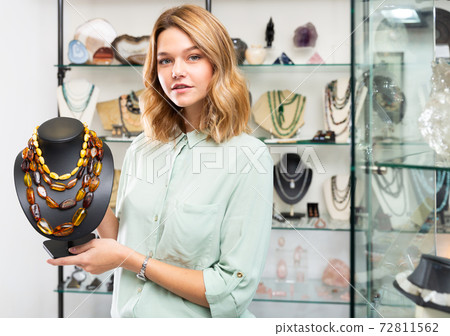 Woman demonstrating natural amber necklace 72811562