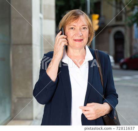 Elderly woman talking on mobile phone 72811637
