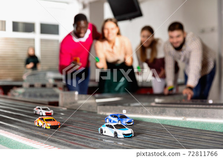 Slot car racing track. Emotional players drive toy cars Slot car racing track. Emotional players drive toy cars 72811766