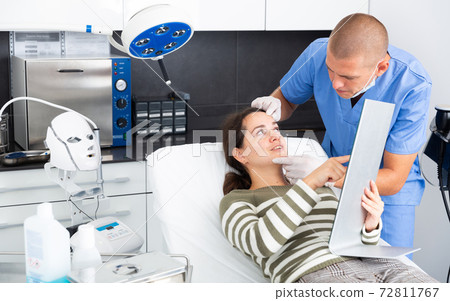 Beautician examining female face skin after procedure Beautician examining female face skin after procedure 72811767