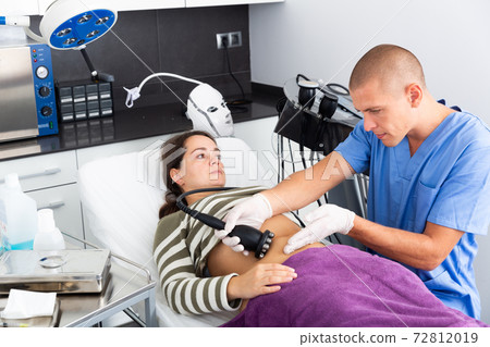 Woman getting ultrasound procedure for body contouring Woman getting ultrasound procedure for body contouring 72812019