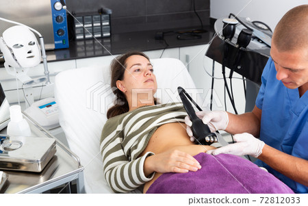 Beautician performing rf lifting procedure for female patient Beautician performing rf lifting procedure for female patient 72812033