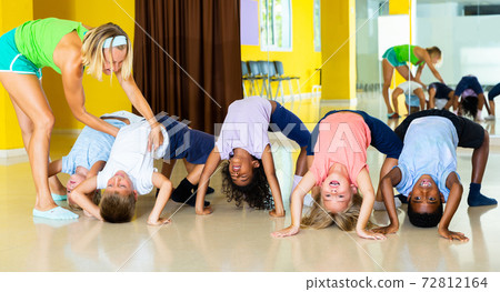 Children with trainer stretching in dance classroom Children with trainer stretching in dance classroom 72812164