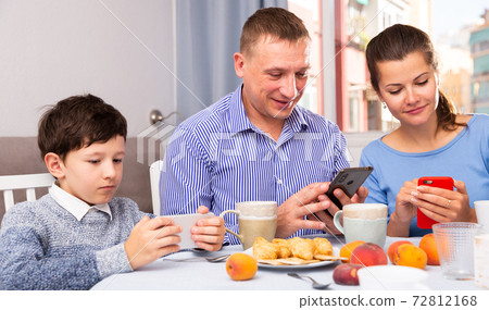 Boy and his parents using phones 72812168