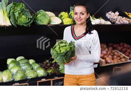 Woman choosing cabbage in grocery shop Woman choosing cabbage in grocery shop 72812218