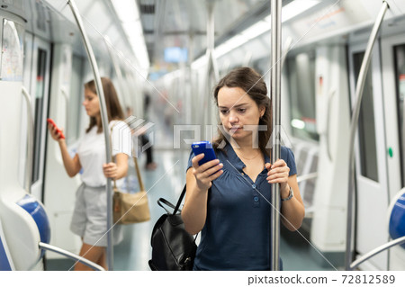 Woman with smartphone in subway car Woman with smartphone in subway car 72812589