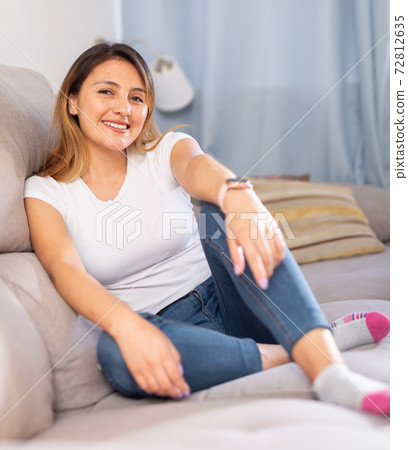 Positive latino woman resting on sofa at home Positive latino woman resting on sofa at home 72812635