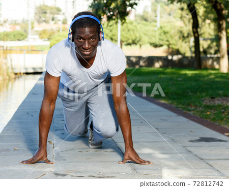 Athletic african american man starting running in park outdoor 72812742
