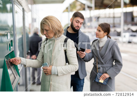 Mature woman buying ticket for public transport 72812914
