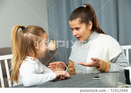 Happy young woman chatting with her small daughter 72812940