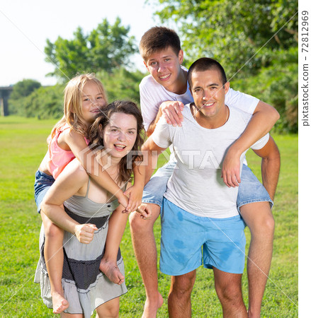 Family of four playing in the summer park Family of four playing in the summer park 72812969