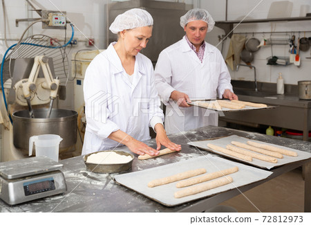 Female baker shaping dough 72812973