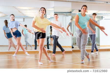 Teenagers in dance hall studying new movements Teenagers in dance hall studying new movements 72812980