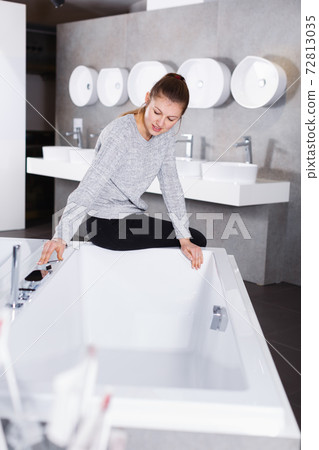 Positive girl customer buying ceramic bath in store Positive girl customer buying ceramic bath in store 72813035
