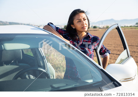 Portrait of latino woman standing near car Portrait of latino woman standing near car 72813354