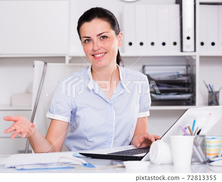 Portrait of young smiling female in the office Portrait of young smiling female in the office 72813355