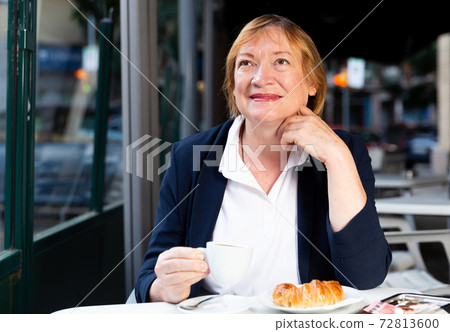 Senior woman having breakfast in cafe Senior woman having breakfast in cafe 72813600