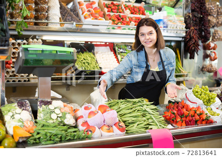 Cheerful woman seller displaying assortment Cheerful woman seller displaying assortment 72813641