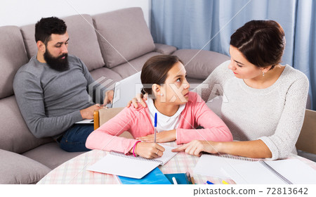 Mother helping daughter with homework Mother helping daughter with homework 72813642
