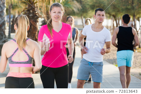 People running along embankment 72813643