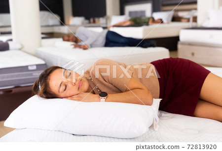Young latin american woman sleeping on mattress in furniture shop 72813920