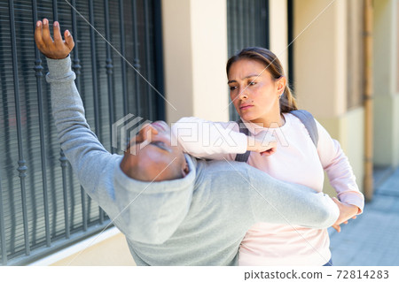 Woman applies force grab to burglar on street Woman applies force grab to burglar on street 72814283