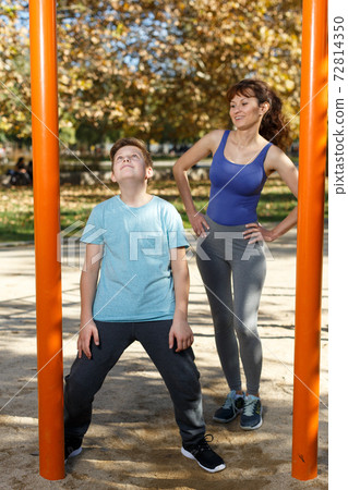 Family doing exercises on horizontal bar Family doing exercises on horizontal bar 72814350